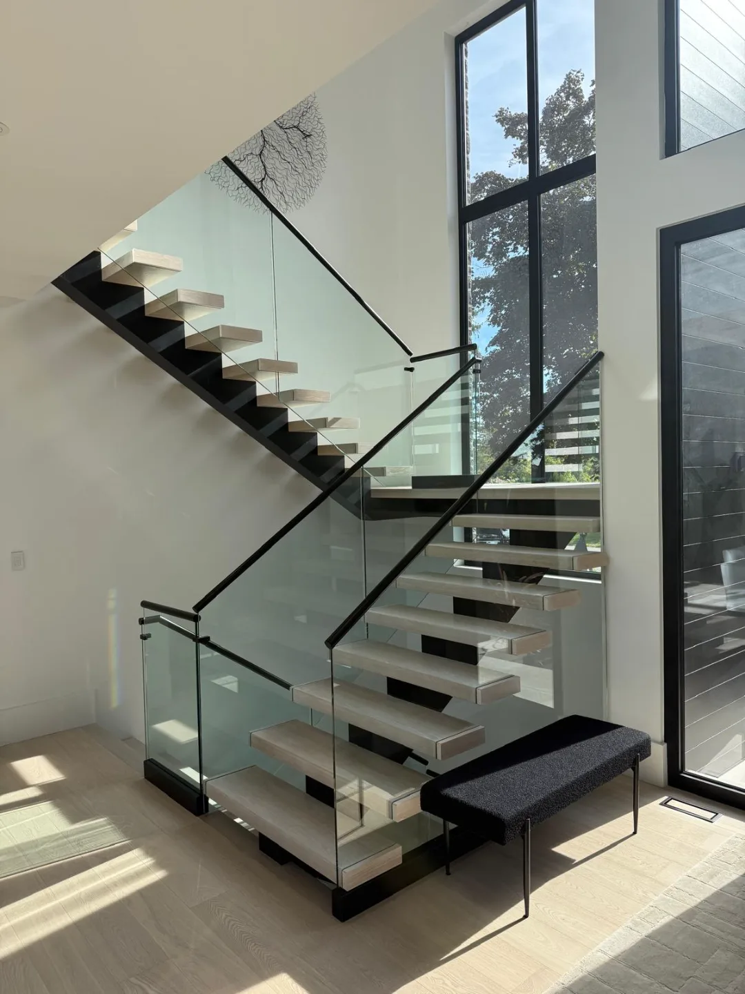 Interior glass railing with stainless handrails on the same double-height build