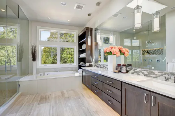 Custom mirror wall above a double vanity — full-width reflection with pendant lighting