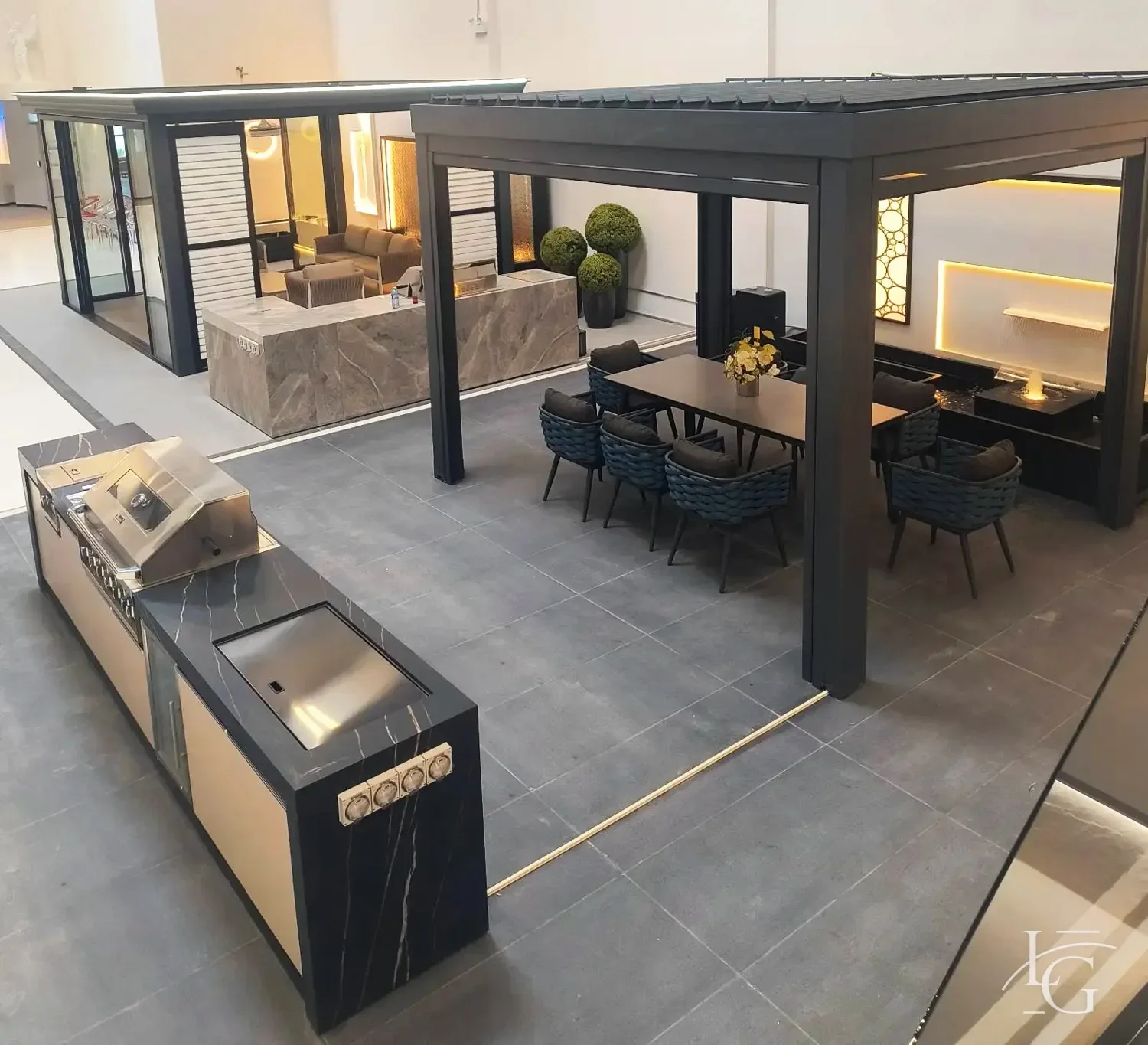 Aluminum louvered pergola over an outdoor living and dining area with glass walls and an outdoor kitchen