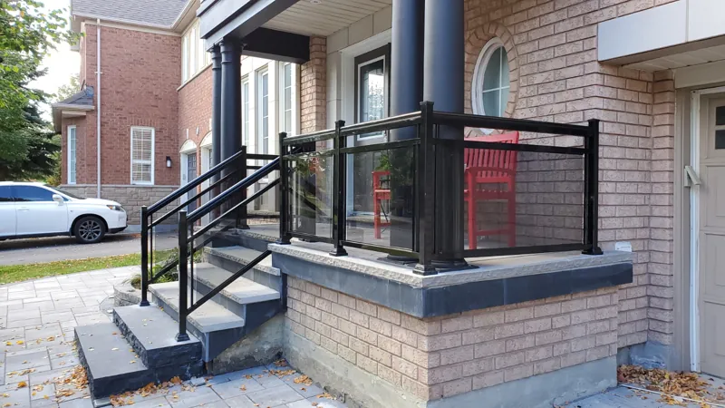 Black aluminum framed glass railing on a front porch and steps