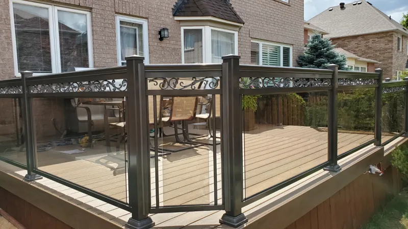 Black aluminum framed glass railing with decorative top band, model GR6, around a deck