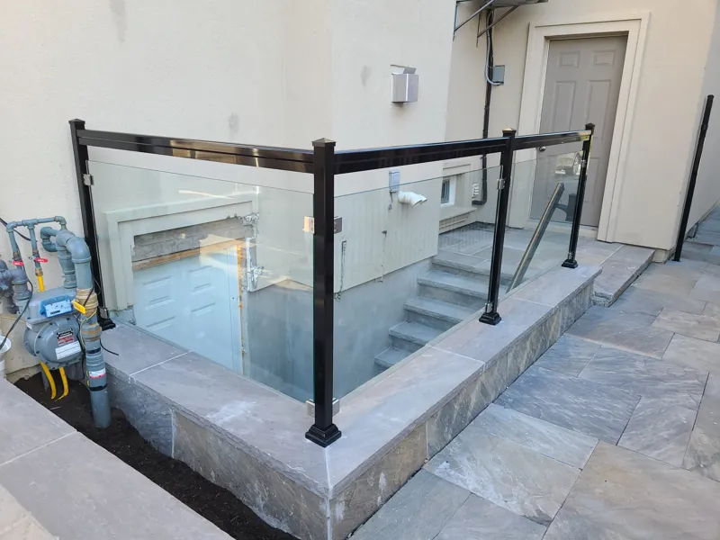 Black aluminum post glass railing, model GRF2, with clear glass around a lower stairwell
