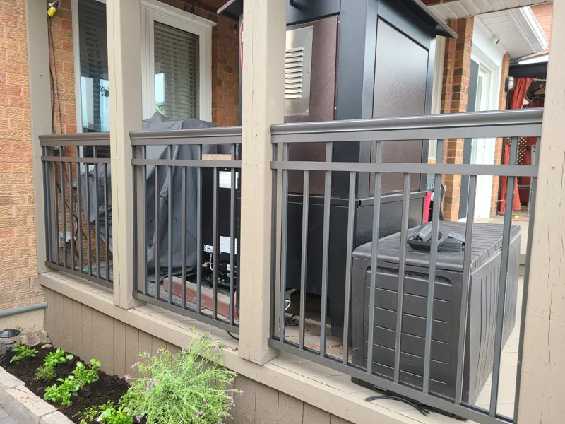 Grey aluminum picket railing between porch columns