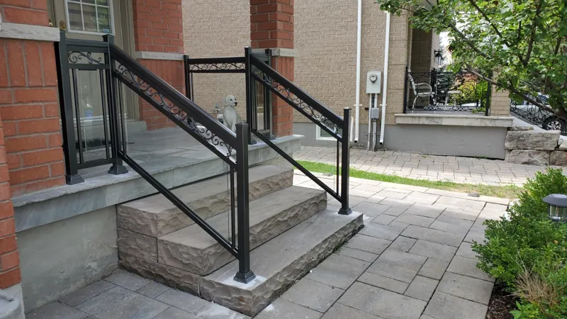 Black aluminum picket railing on both sides of stone entry steps