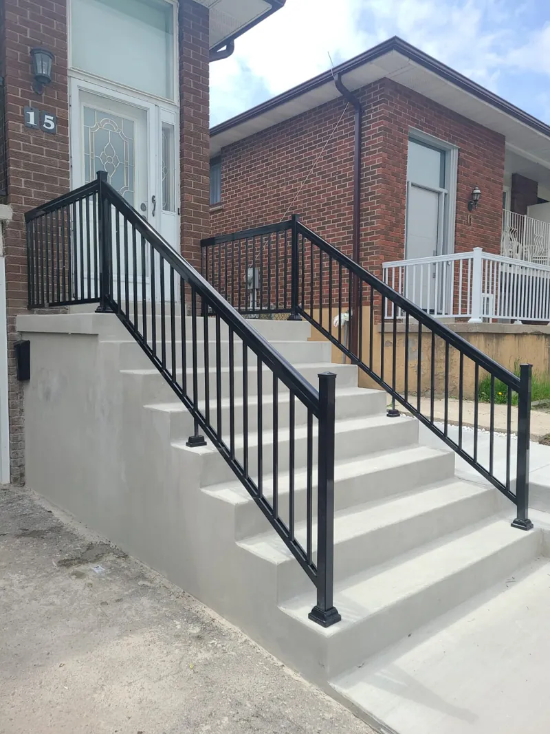 Black aluminum picket railing, model R1, on both sides of concrete entry steps
