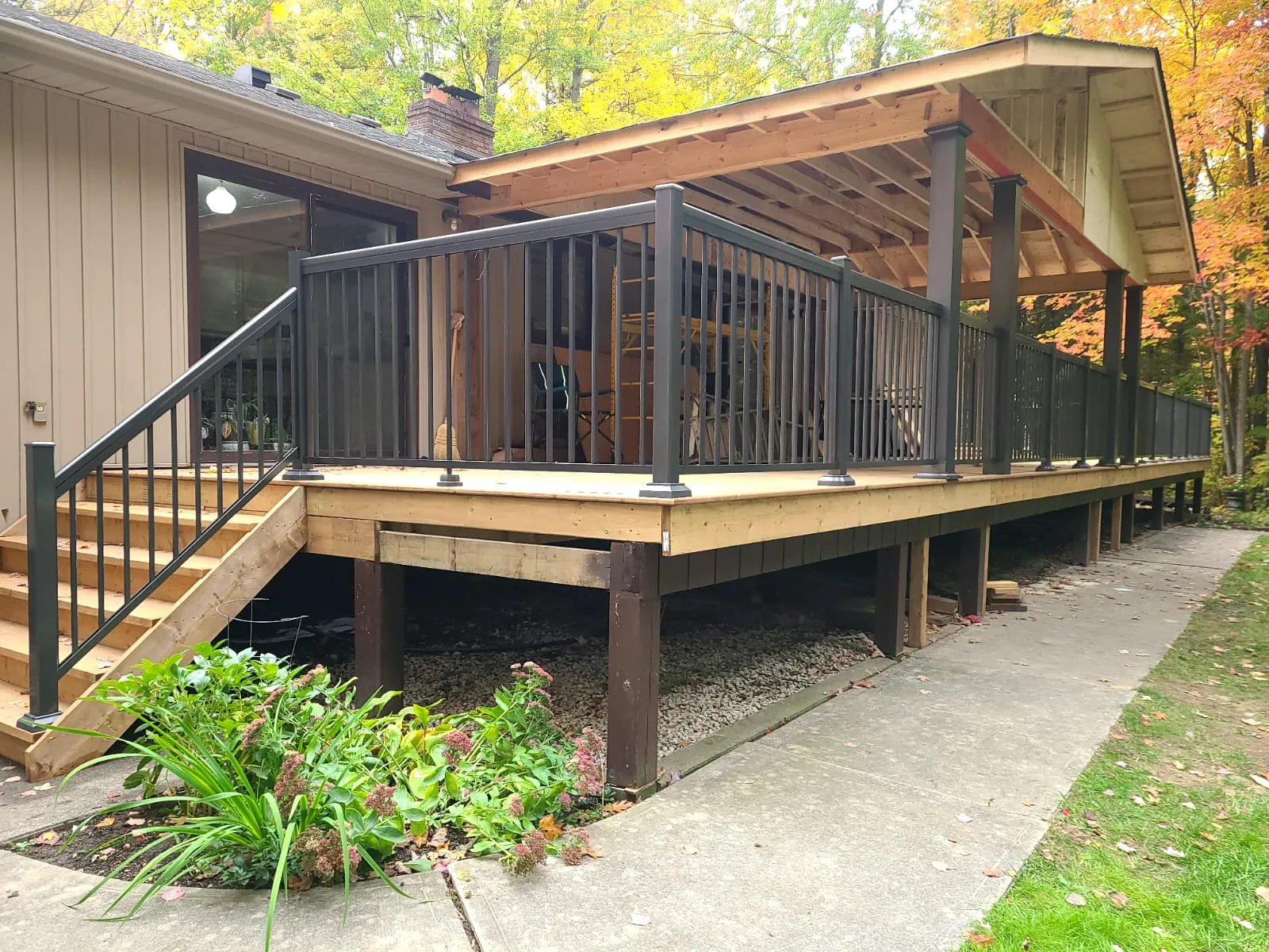 Black aluminum picket railing, model R1, around a raised wood deck and stair