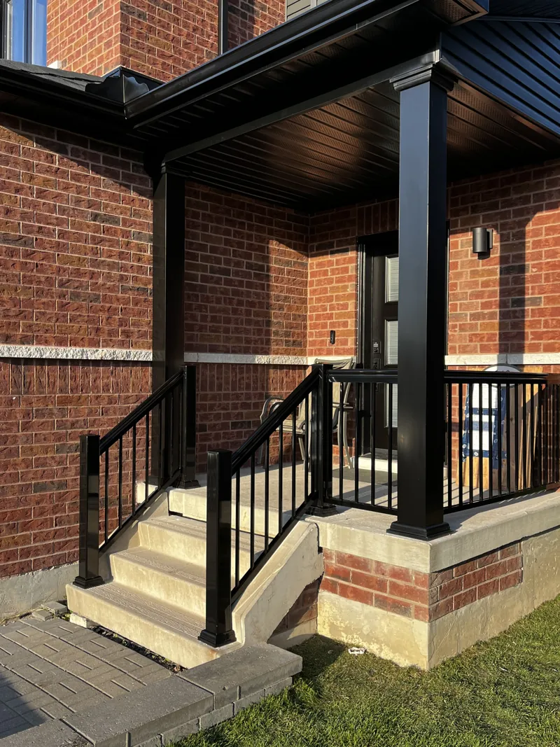 Black aluminum picket railing, model R1, on porch steps beside a large square column