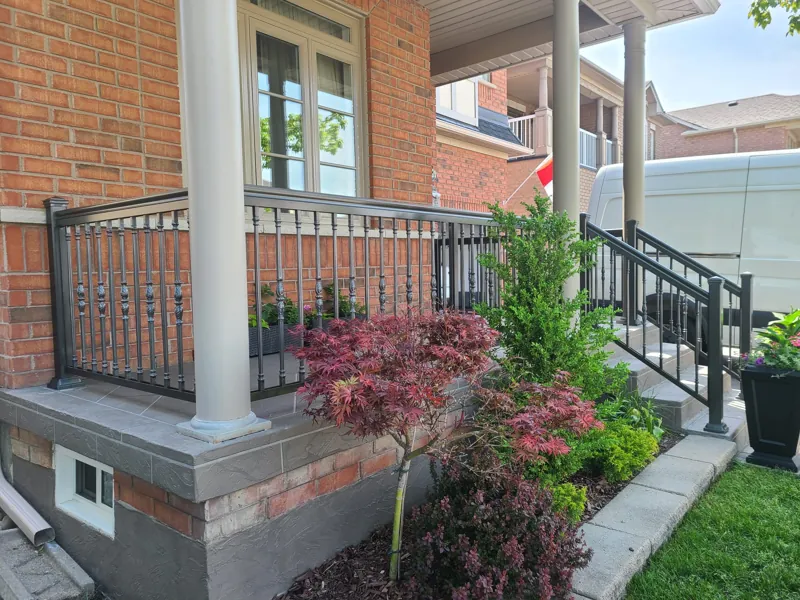 Black aluminum picket railing, model R19, on a front porch and steps