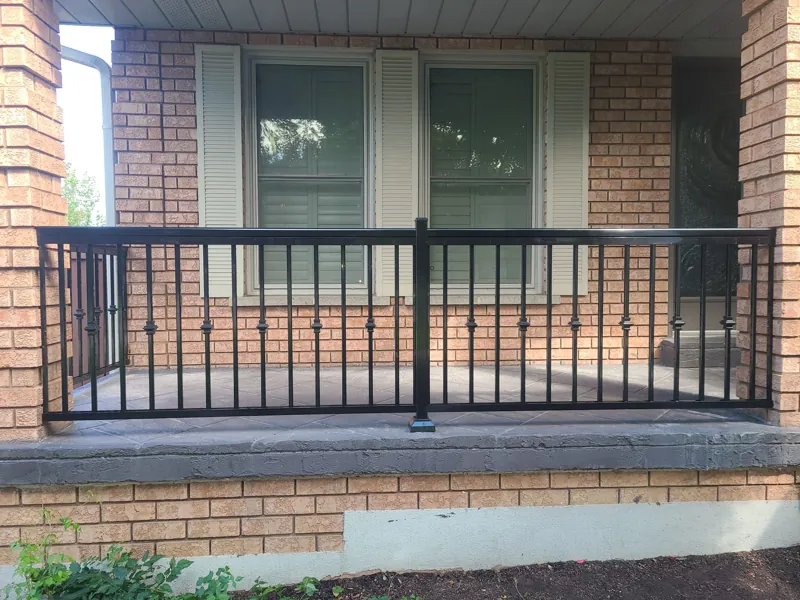 Black aluminum picket railing, model R2, across a brick front porch