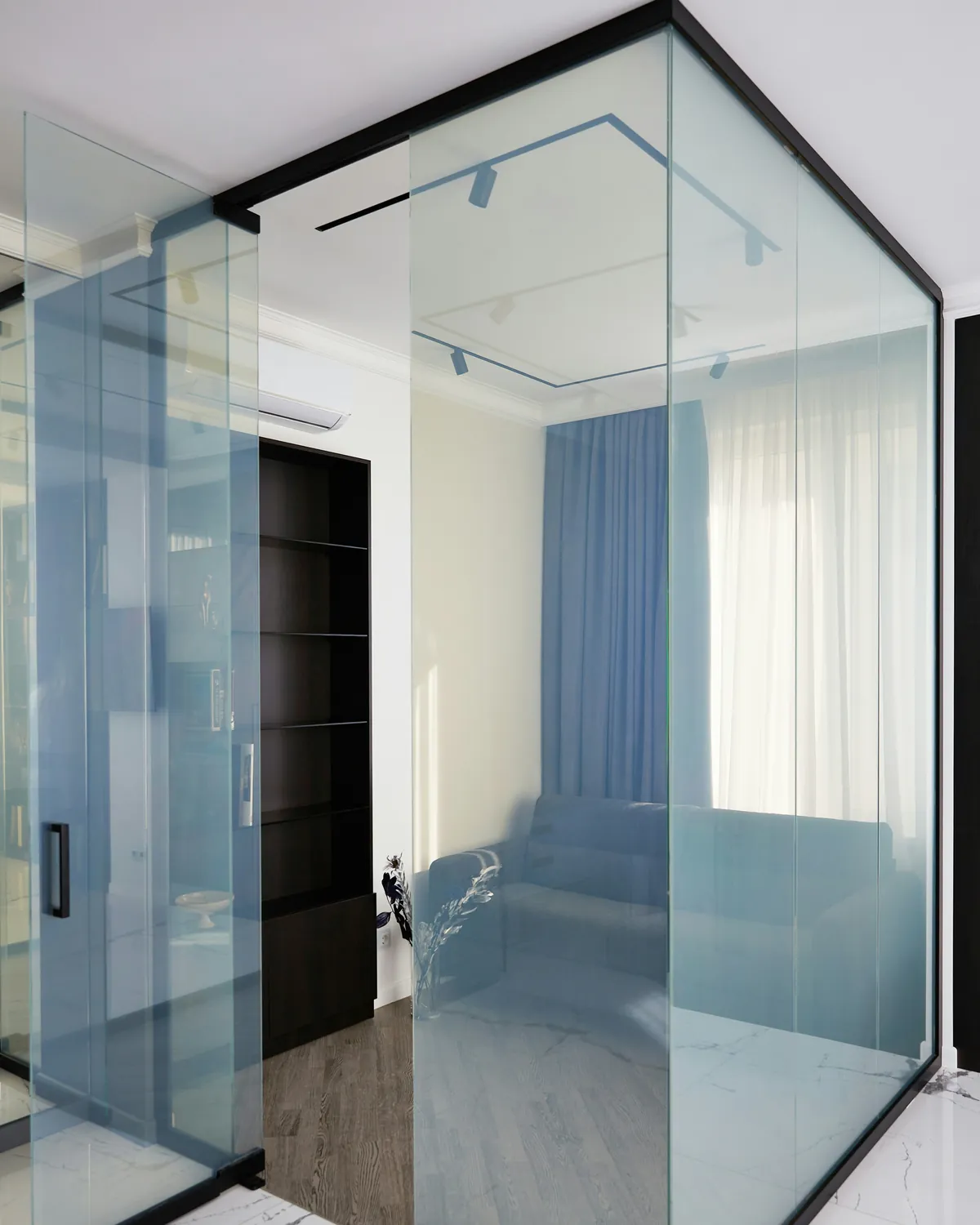 Clear glass room with black frame and an open glass door, shown in the clear state