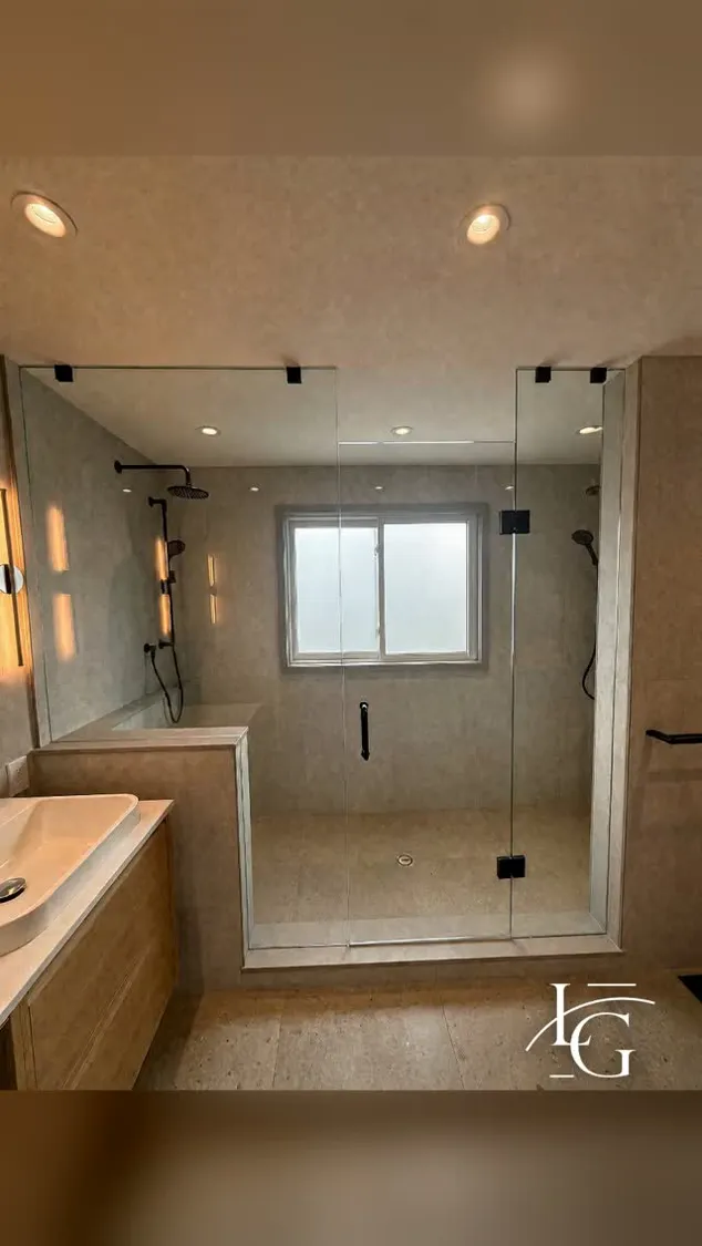 Frameless shower installed by Lux Glass in Hamilton, matte black hardware