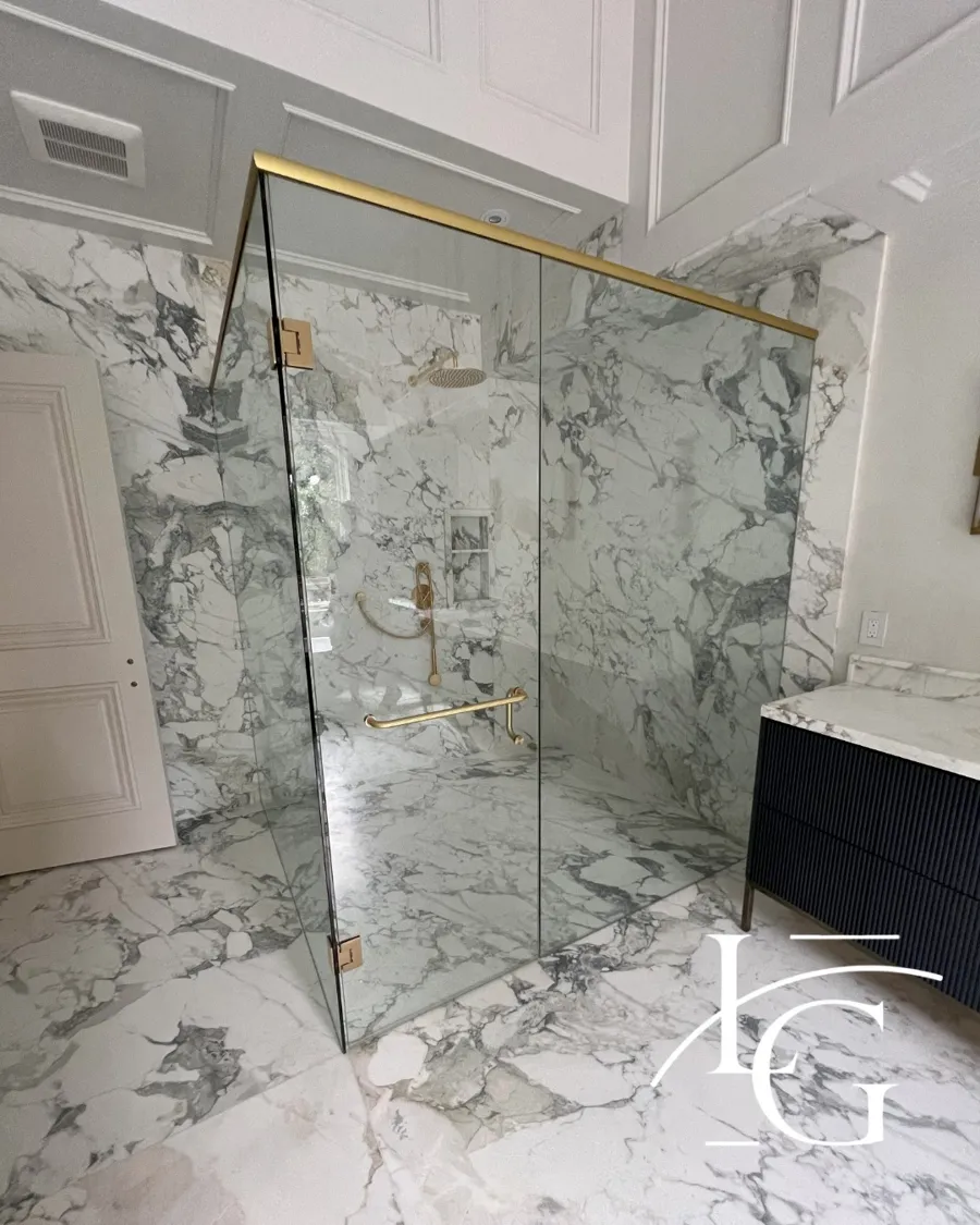 Frameless shower installed by Lux Glass in Toronto, brass and gold hardware